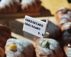LettrBoard three-row sign reading CHEESECAKE CROISSANT among croissants