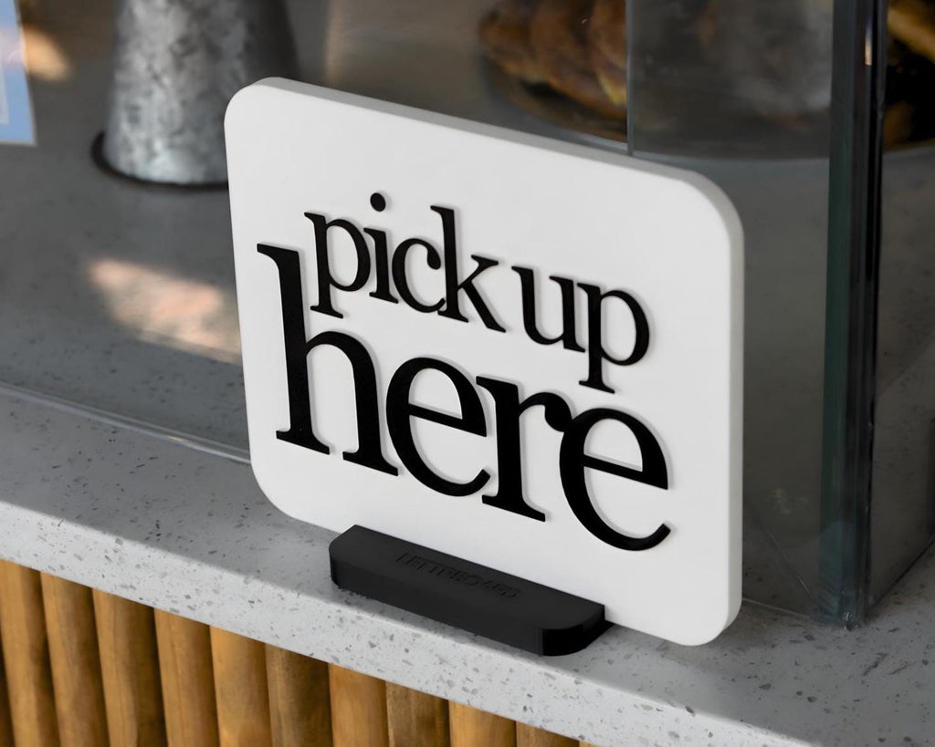 LettrBoard Pick Up Here sign with raised lettering on a dual-slot base