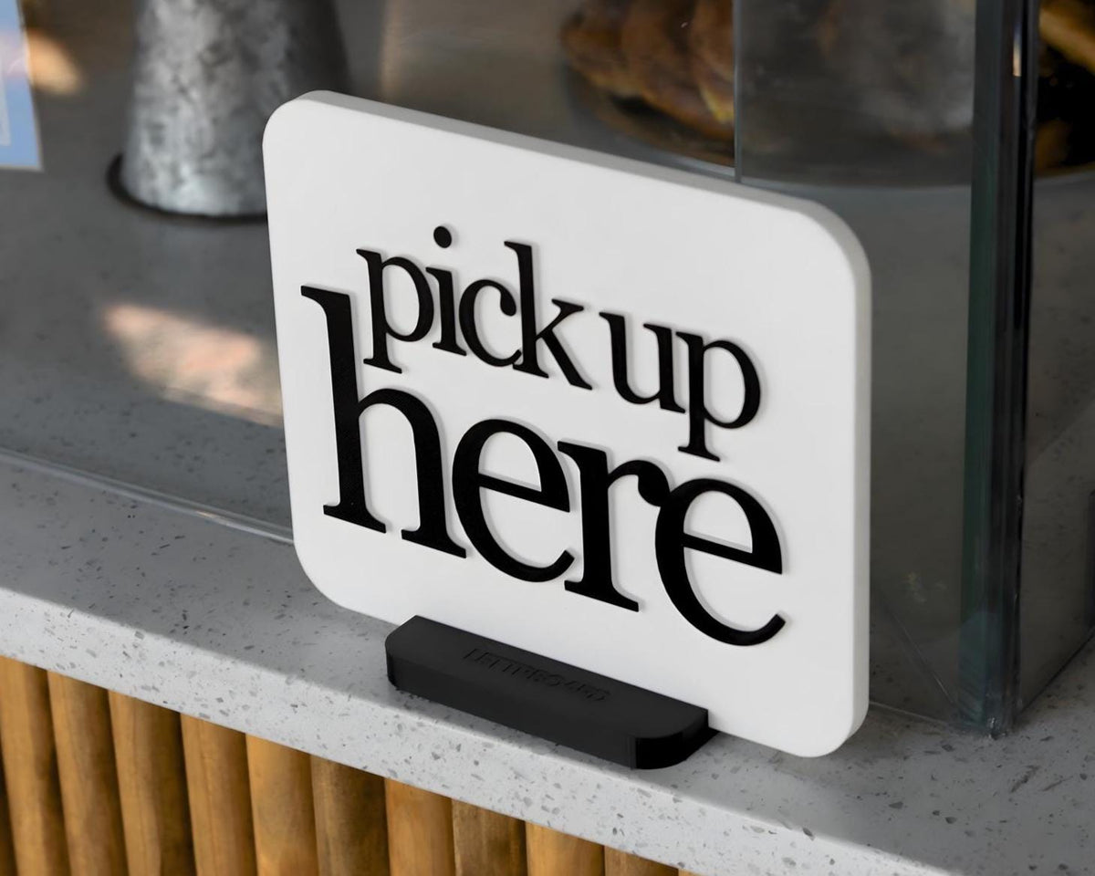 LettrBoard Pick Up Here sign with raised lettering on a dual-slot base