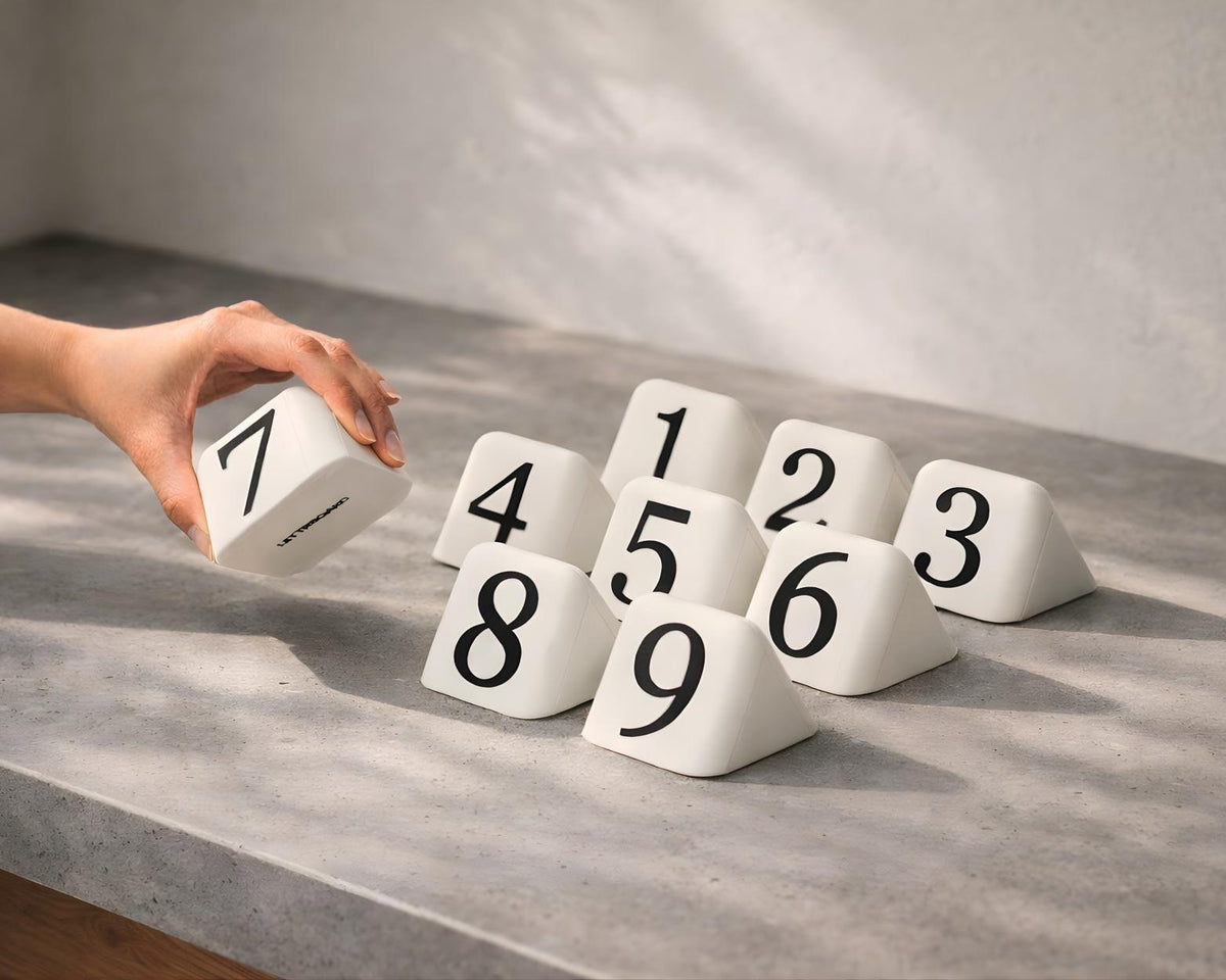 Hand arranging LettrBoard rounded triangular table numbers 1 to 9