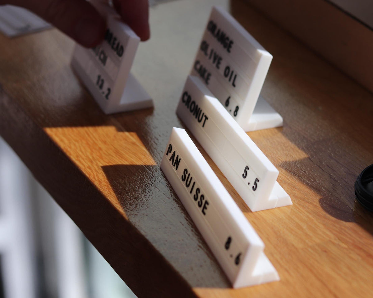 LettrBoard row counter signs lined up on a wooden shelf edge