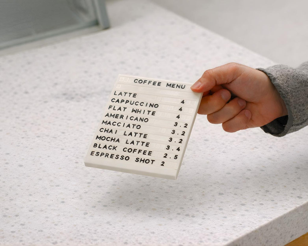 Hand sliding a character into a LettrBoard modular tabletop menu sign
