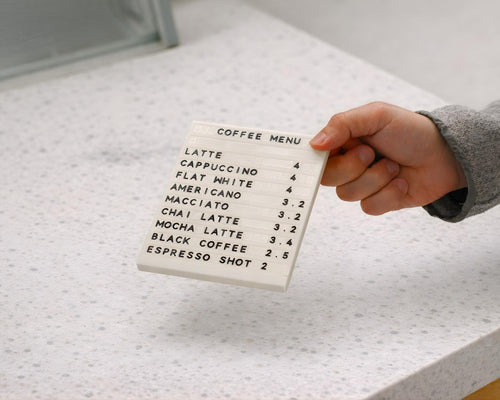 Hand sliding a character into a LettrBoard modular tabletop menu sign