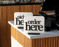 LettrBoard Order Here and Pick Up Here signs on a café counter